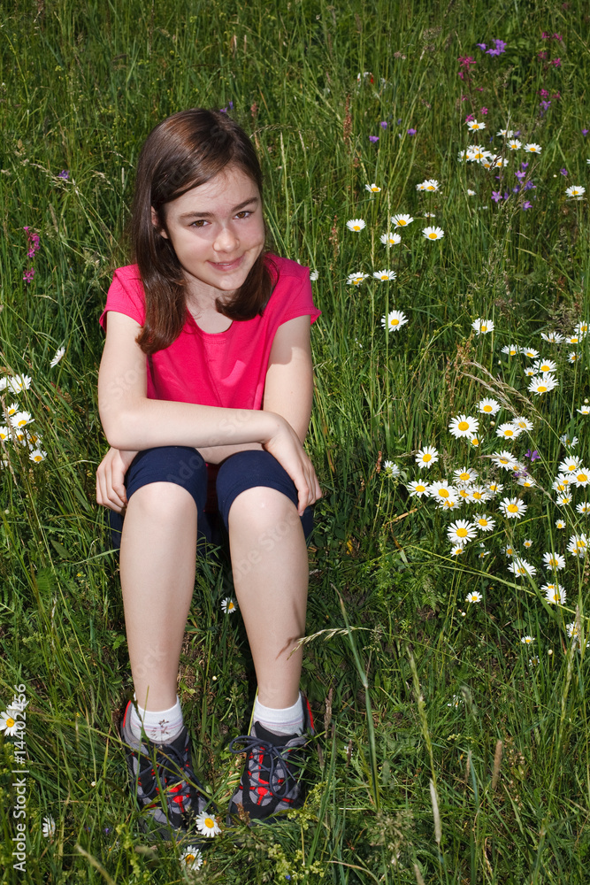 Fototapeta premium Girl sitting on green meadow