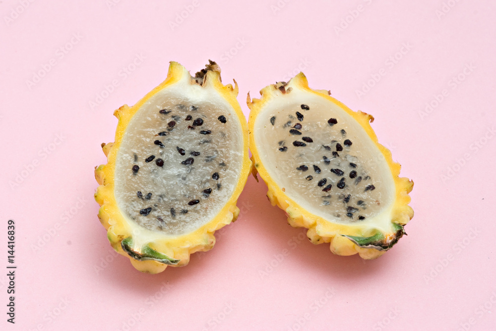 Fototapeta premium Yellow dragon fruit sections isolated on pink background