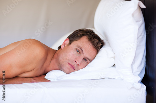 Attractive man relaxing on bed