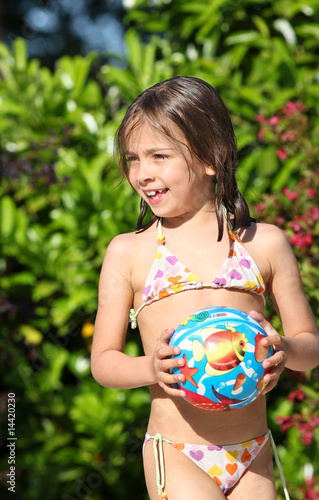 fillette tenant son ballon de plage 2 Photos | Adobe Stock