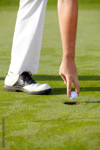 Golfspieler nimmt Ball aus dem hole