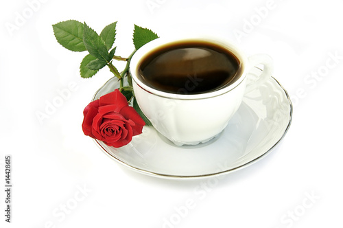 Cup of coffee and small red rose isolated over white.