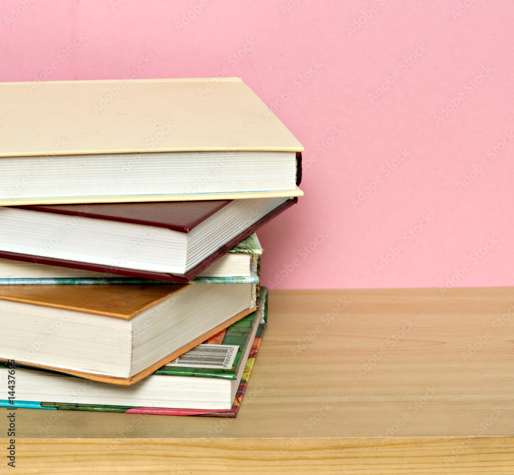 Pile of colorful books isolated on pink background Pile of colorful books isolated on pink background