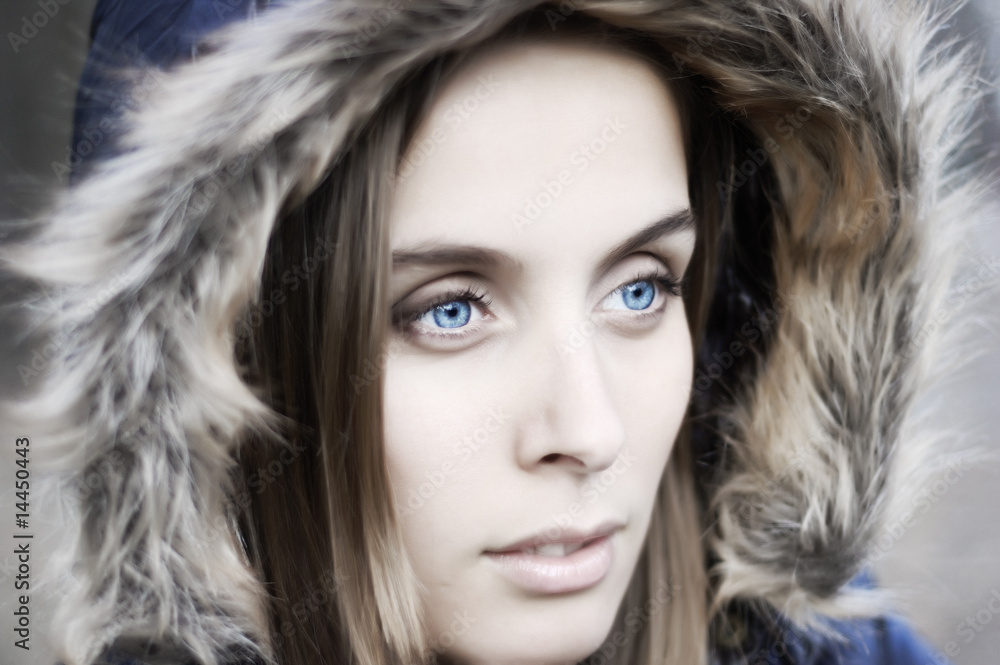 Portrait of a beautiful blue eyed young woman with a hood
