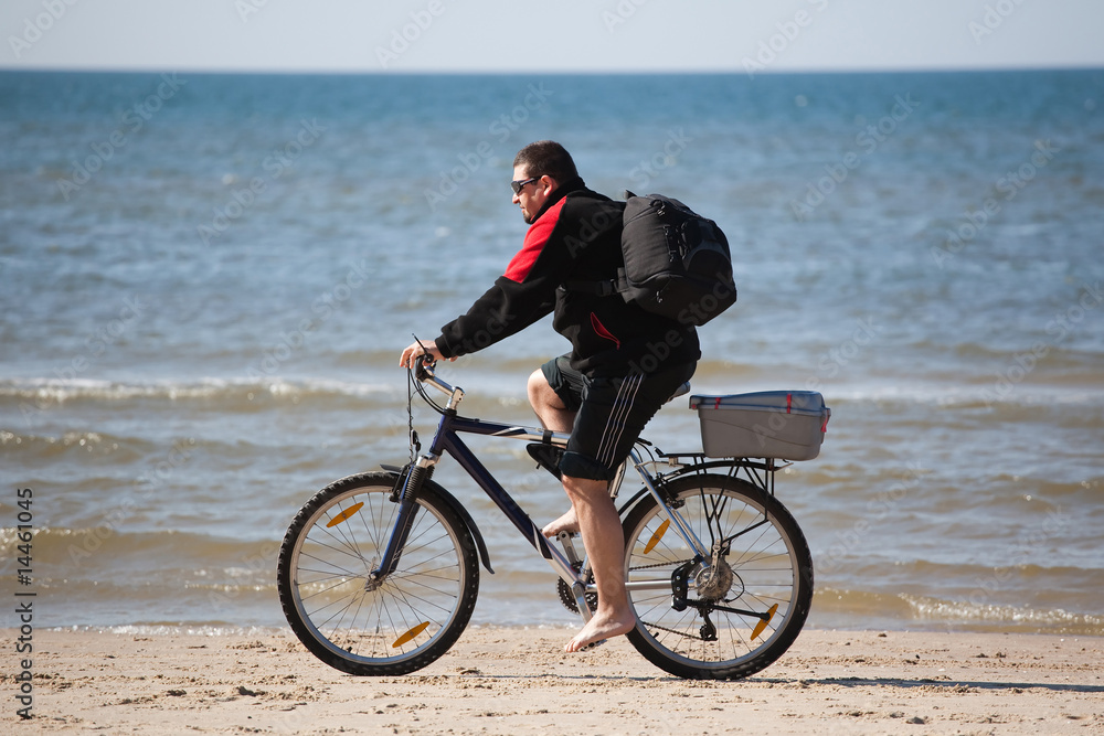 man riding mountain bike on the beach