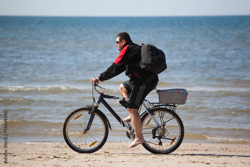 man riding mountain bike on the beach man riding mountain bike on the beach