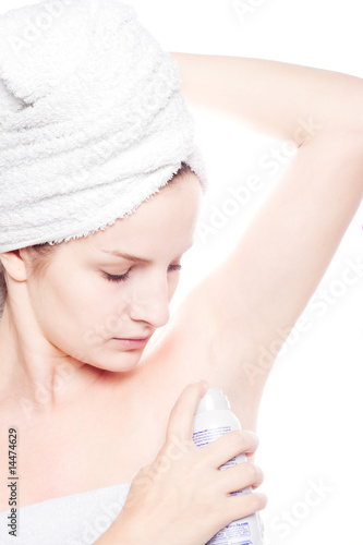 Woman in towel with deodorant spraying