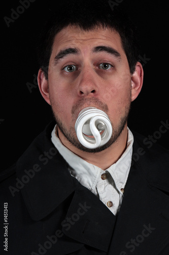 funny male with lightbulb in mouth isolated on black background