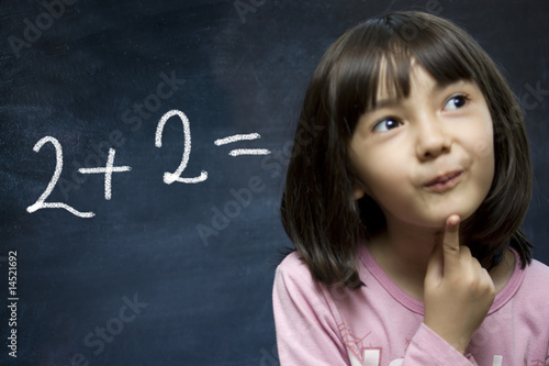 Schoolgirl stay near school blackboard.