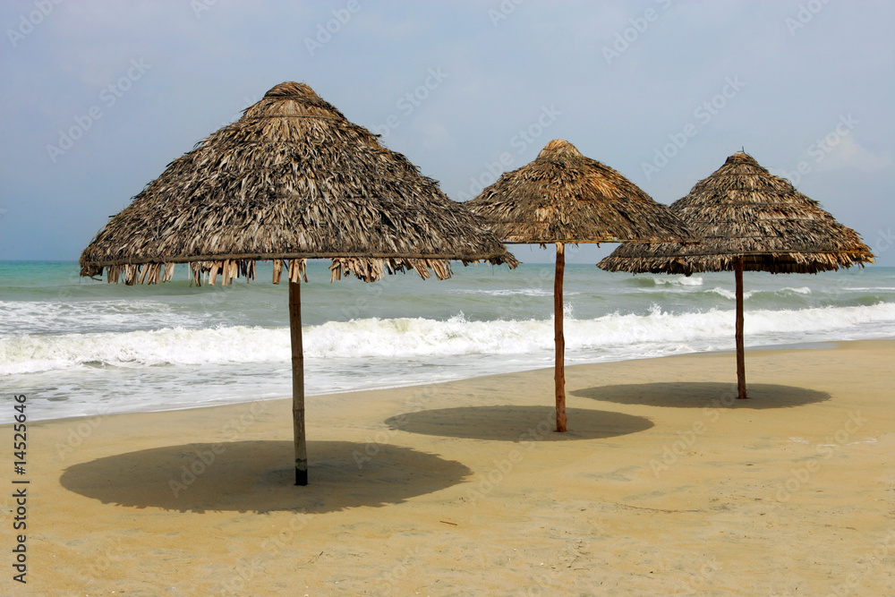 Three Thatched umbrellas on deserted beach, Hoi An, Vietnam