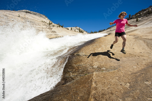 Hiker running near cascades.