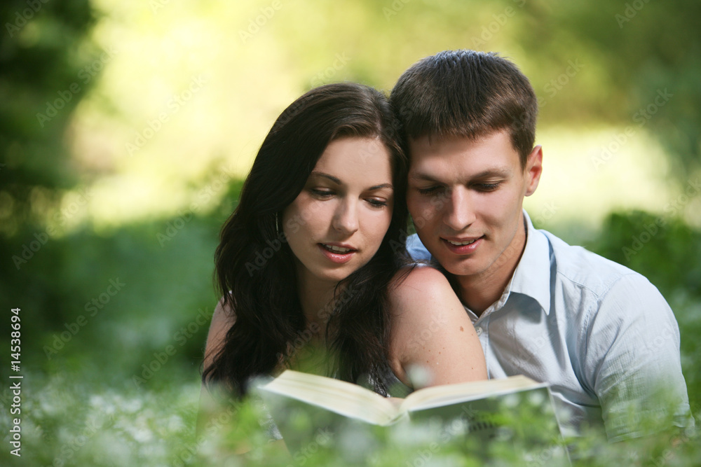 Man and woman sitting on the grass and reading. Man and woman sitting on the grass and reading.