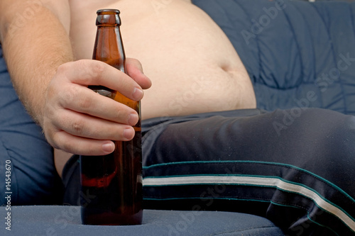 Men sitting on the sofa with a bottle of beer