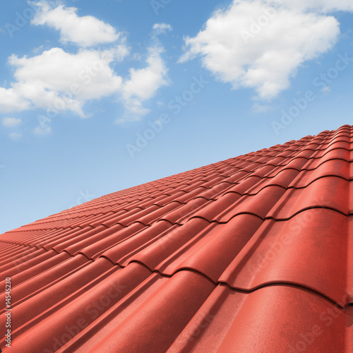 View of red roof tiles and cloudy sky on the background.