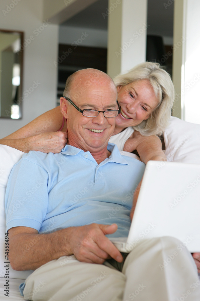 old man and old woman smiling with laptop