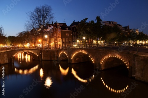 A panorama of a canal at night in Amsterdam.