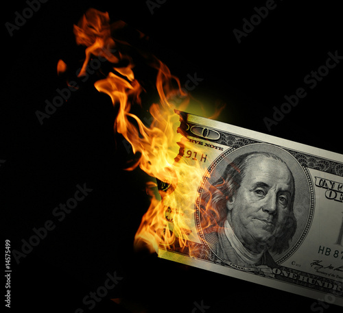 Burning dollars close up over black background