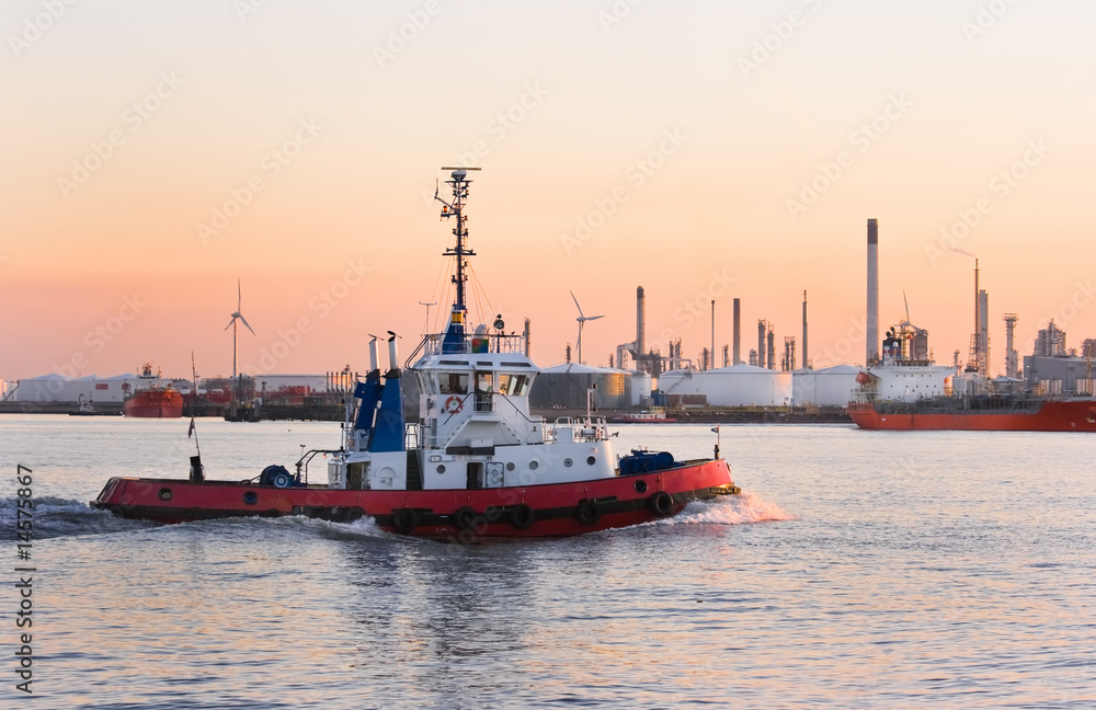 Tug passing by on the river at sunset