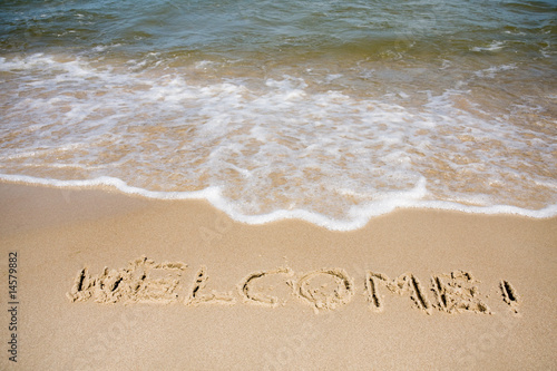 Welcome written in sandy beach