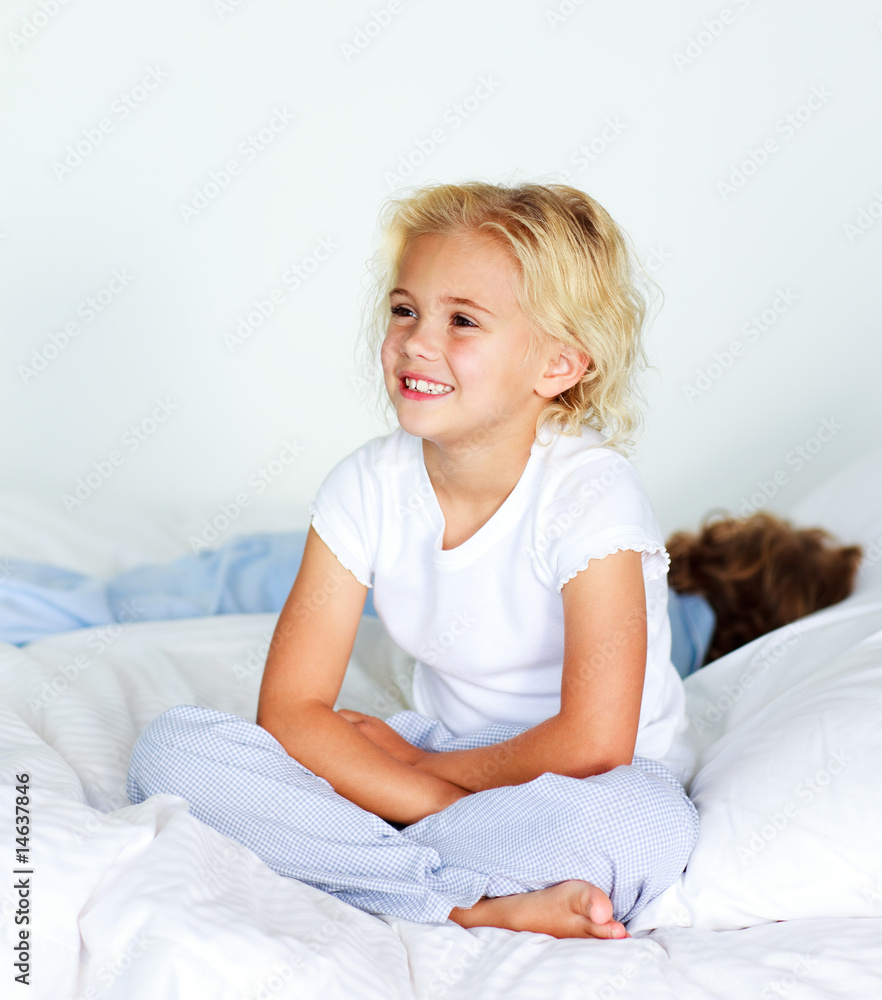 Little girl sitting on bed before sleeping Little girl sitting on bed before sleeping