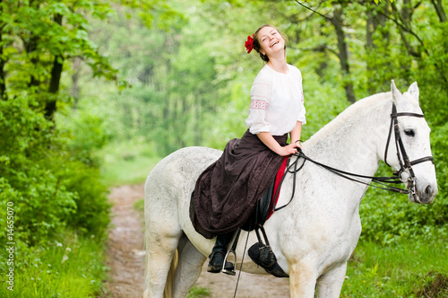 Laughing girl riding horse