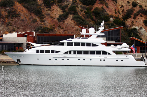 white luxury yacht moored in harbor