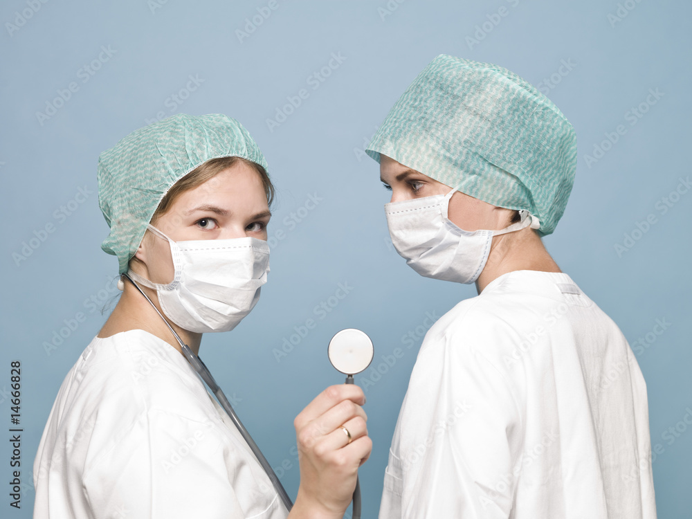 Two female nurses with sugical masks and a stethoscope Two female nurses with sugical masks and a stethoscope
