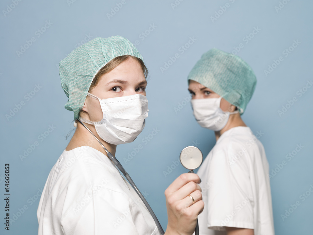 Two female nurses with surgical masks and a stethoscope Two female nurses with surgical masks and a stethoscope