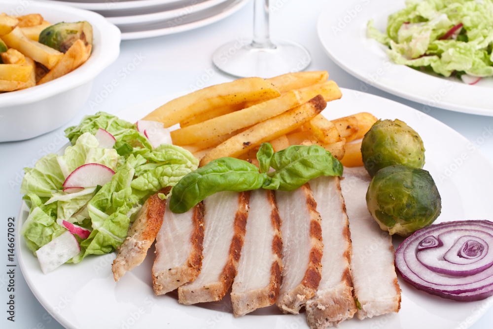 sliced pork chops with fries and brussels sprouts