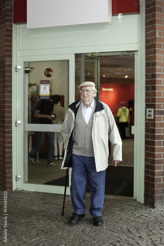 Old man coming out of his bank