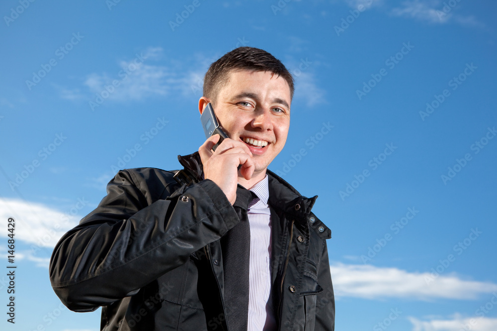 man on mobile phone on natural blue background man on mobile phone on natural blue background