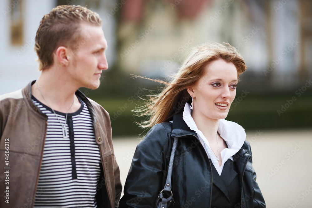 Fototapeta premium Junges Paar geht Arm in Arm spazieren