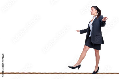 Businesswoman walking a tightrope isolated on white.
