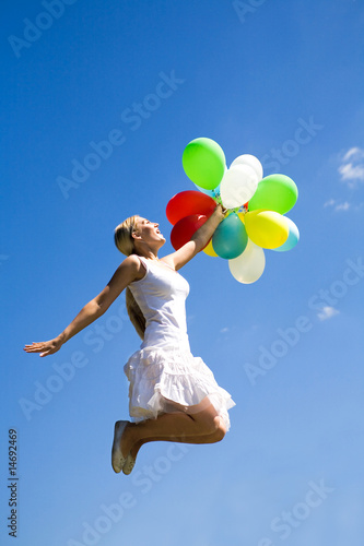 Woman jumping with balloons