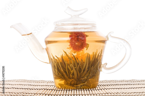 Fotografija teapot with green tea on mat