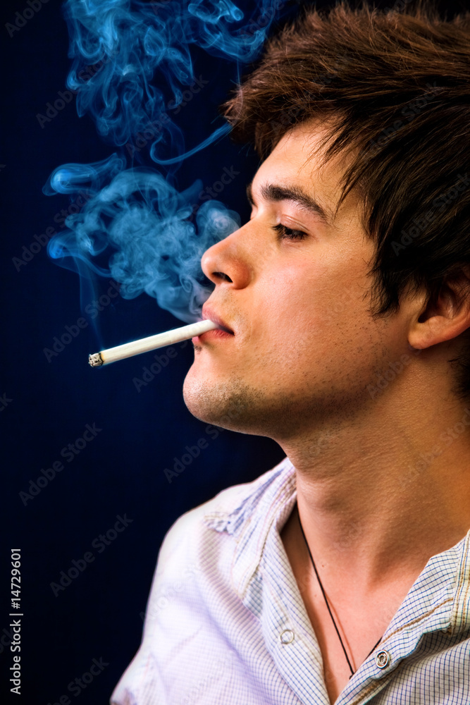 Fototapeta premium Sexy cool young man smoking a cigar