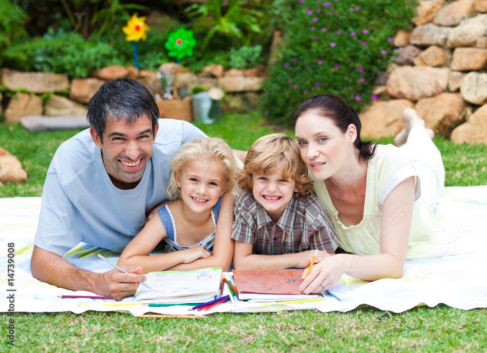 Happy family painting in a park smiling at the camera Happy family painting in a park smiling at the camera