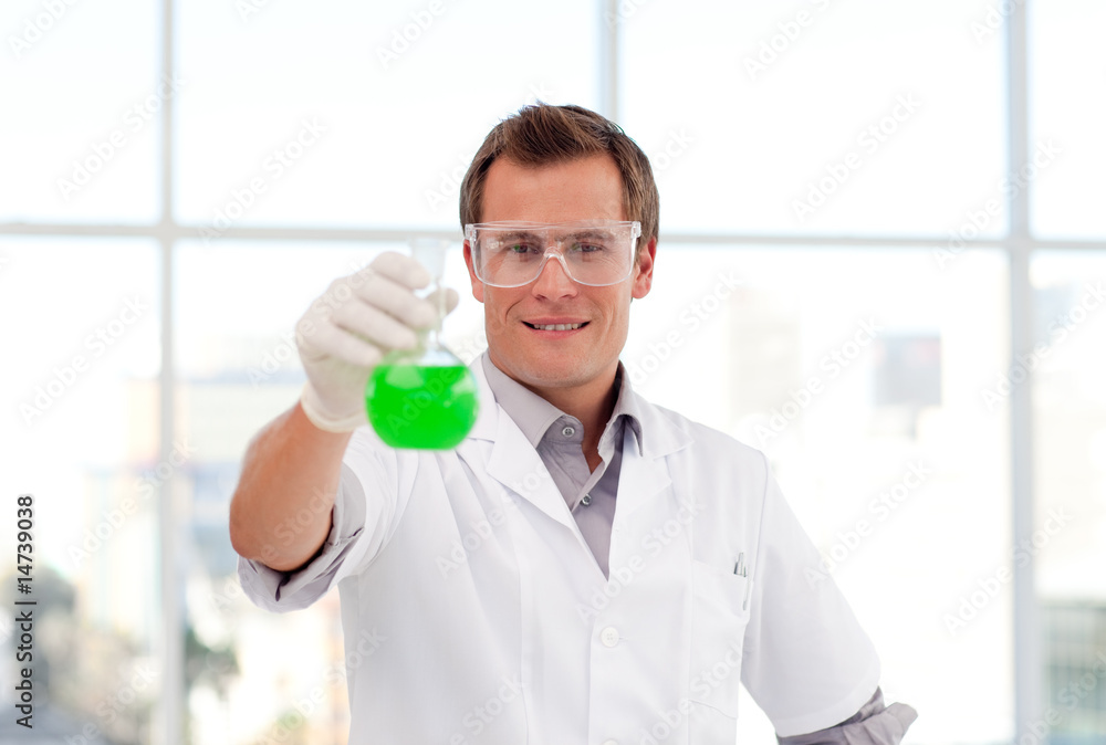 Smiling scientist examining a test-tube Smiling scientist examining a test-tube