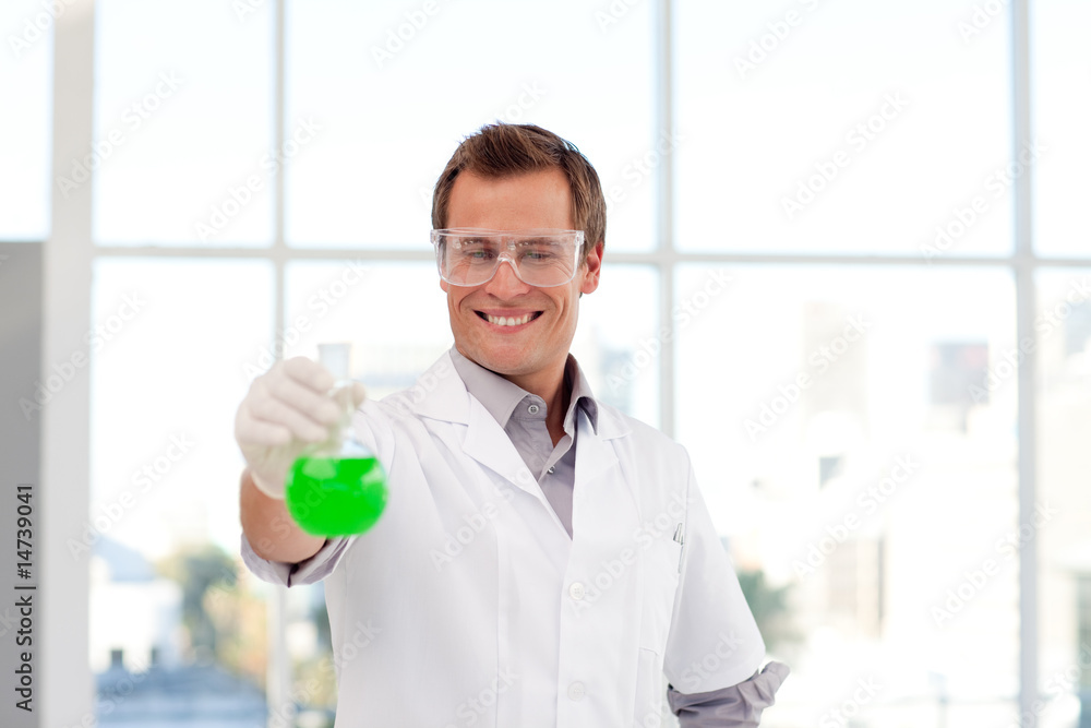 Smiling scientist examining a chemical test-tube Smiling scientist examining a chemical test-tube