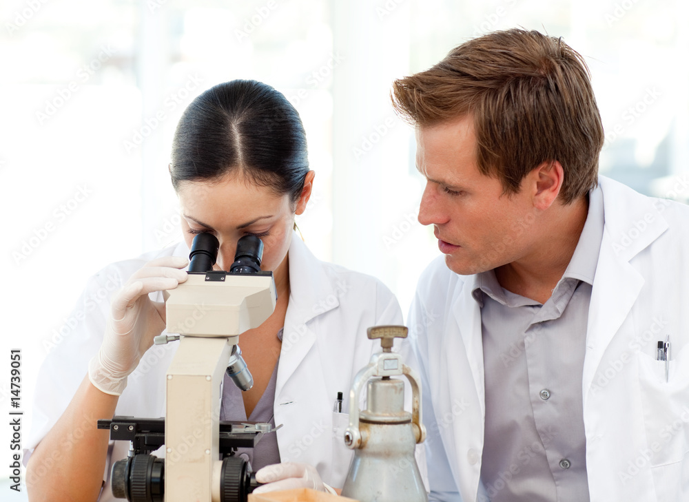 Scientists looking through a microscope