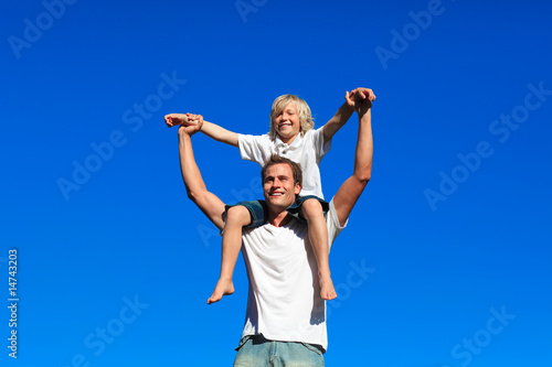 Kid sitting on his father's shoulders