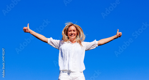 Young woman jumping against blue sky