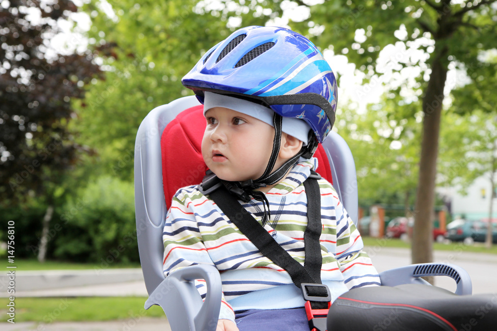 child sitting by bicycle in crash helmet child sitting by bicycle in crash helmet