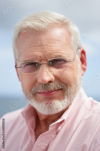 Homme senior souriant portant des lunettes de vue