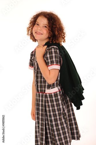 Adorable little girl in school clothes, isolated on white.