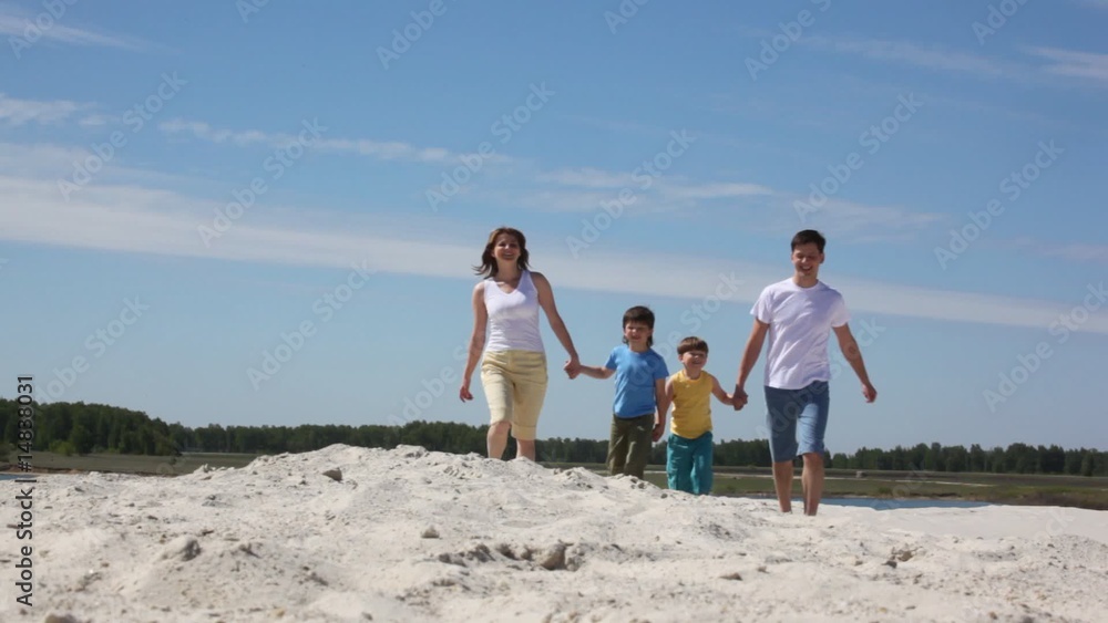 Happy family goes on sand Happy family goes on sand