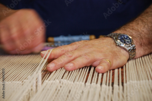 Hands of tapestry master in action