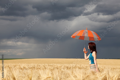 girl with umbrella at wheat field in rainy day