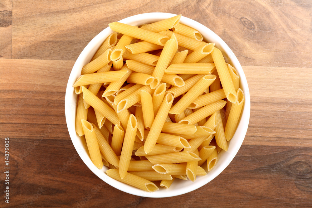 Top view of dry penne rigate in white ceramic bowl Top view of dry penne rigate in white ceramic bowl