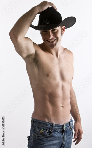 An attractive cowboy with his shirt off in studio